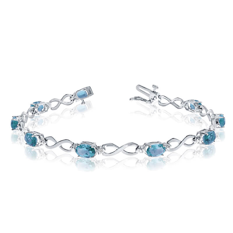 JCX3105: This 10k white gold oval blue topaz and diamond bracelet features nine 6x4 mm stunning natural blue topaz stones with a 3.60 ct total gem weight.