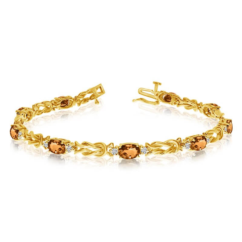 This 14k yellow gold natural citrine and diamond tennis bracelet features 9 oval citrines with a total gem weight of 2.79 carats and a total diamond weight of 0.5 carats.