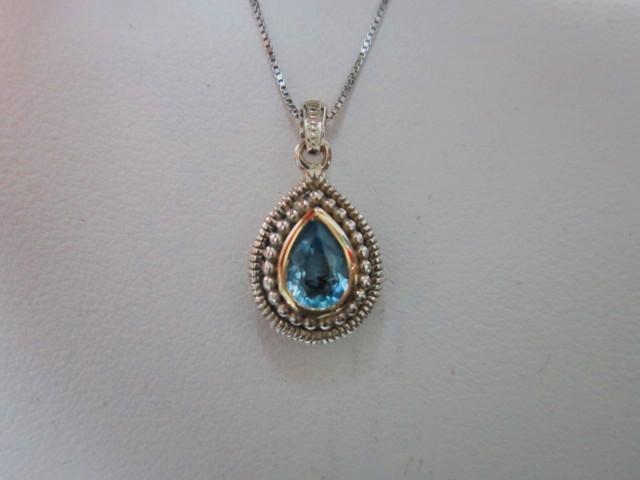 JCSJCS1366: This pendant is nicely detailed particularly if you like an antique style. A Blue Topaz gem set in sterling silver and accented in 14k yellow gold...SOLD