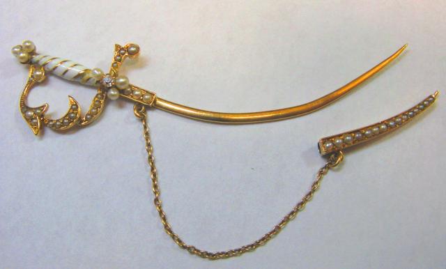 JCSA911: Ornate sword pin.  This 18kt. yellow gold pin has one .02ct. diamond, pearls, as well as, white enamelling.  One of a kind.